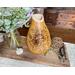 This shows a dinning room centerpiece featuring a handmade gourd vase. The vase has hand-drawn sunflower artwork on the front. 